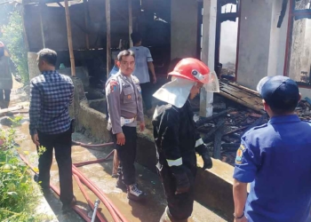 Petugas Damkar dibantu polisi memastikan kebakaran yang menghanguskan dua rumah warga Desa Lebakmekar, Kecamatan Greged, Kabupaten Cirebon, benar-benar padam, Rabu (27/7/2022).* Foto: Istimewa